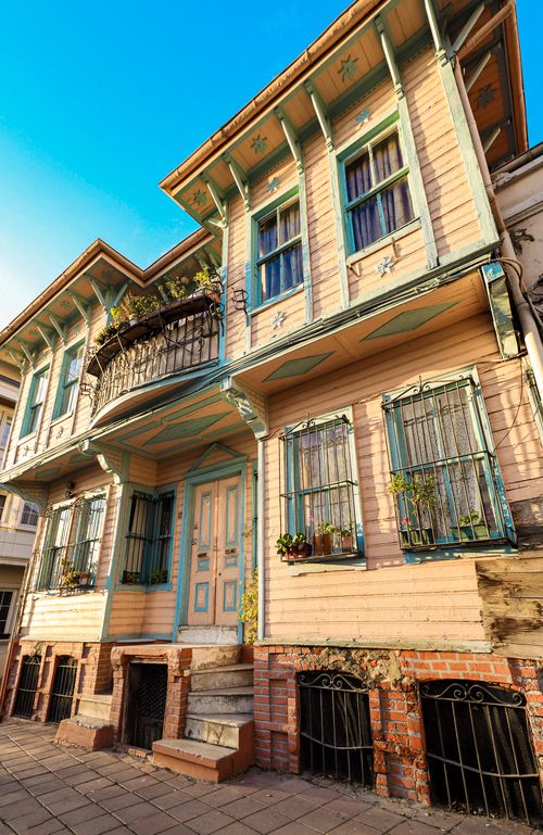 Free Charming old wooden house with colorful trim and balcony, low-angle view. Stock Photo