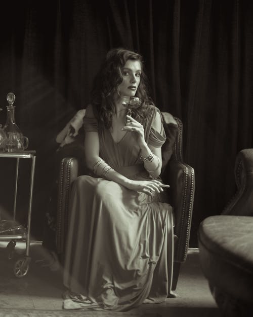 A Woman Holding a Drink while Sitting
