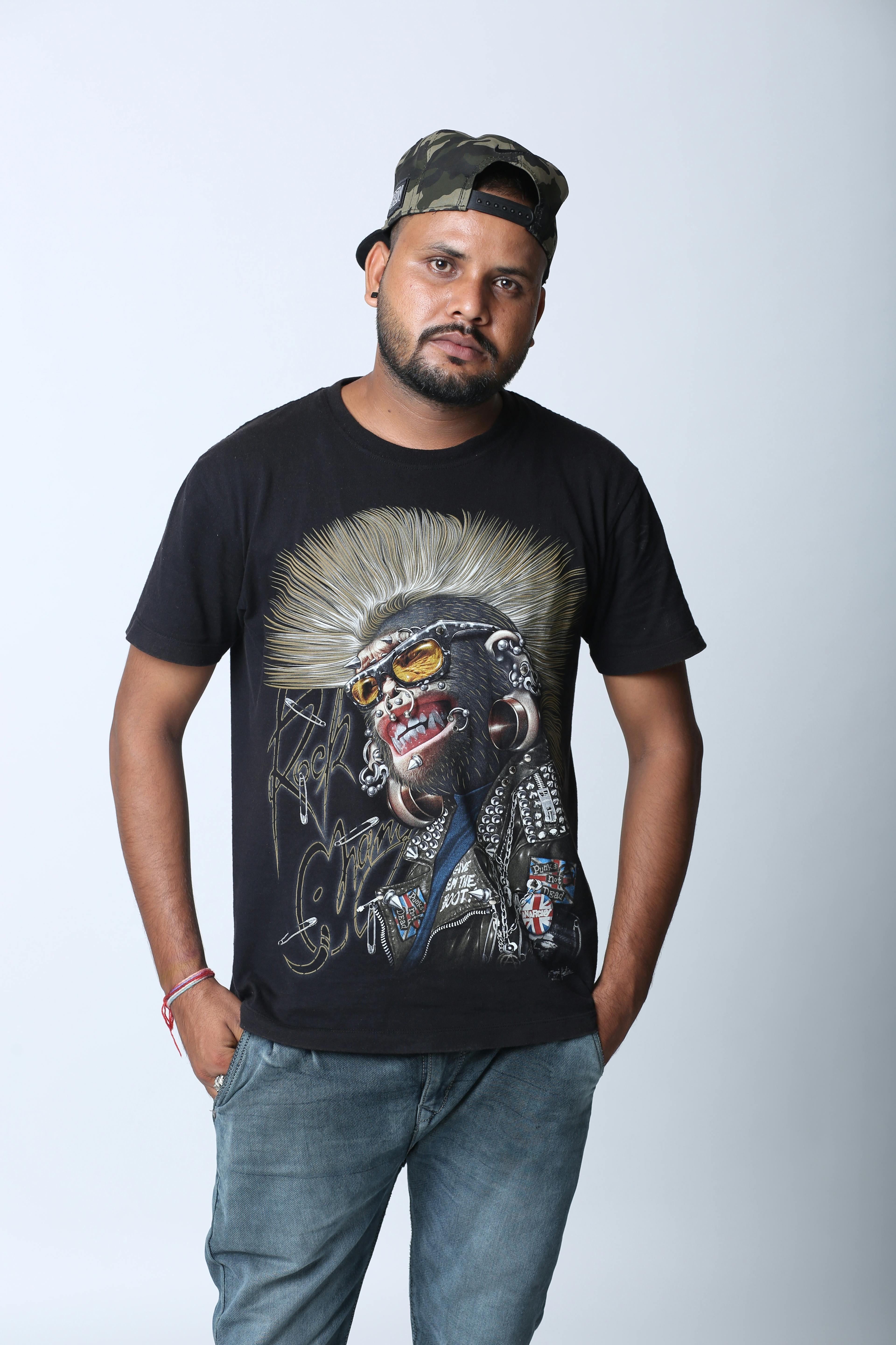 Studio portrait of a man wearing a graphic T-shirt and cap, showcasing a casual style.