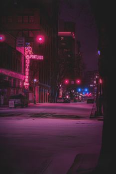 A moody neon-lit street in Portland, Oregon, depicting urban nightlife during winter.