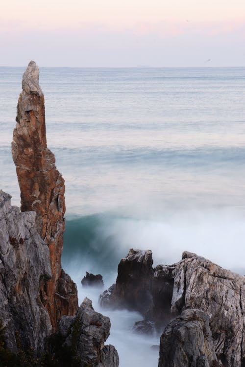 Ocean Waves Crashing on Brown Rock Formation