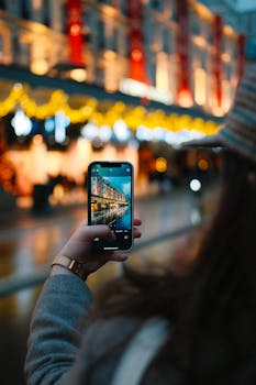 Nighttime street photography focusing on capturing city lights using a smartphone.
