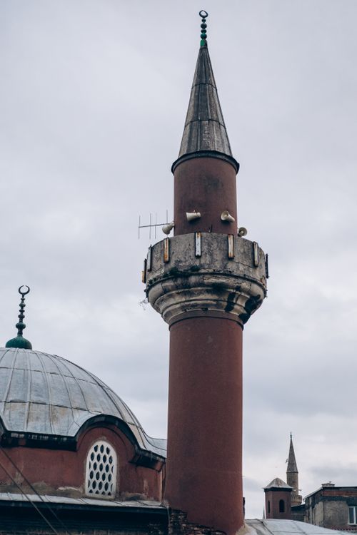 Free Vertical shot of a mosque minaret in a Turkish town, featuring Islamic architecture under a cloudy sky. Stock Photo