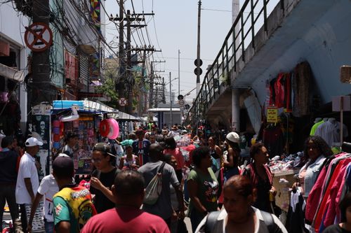 Free Crowded street market in São Paulo with diverse people and colorful stalls. Stock Photo