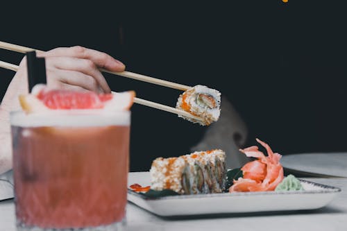 Close-up of Person Eating Sushi with Chopsticks