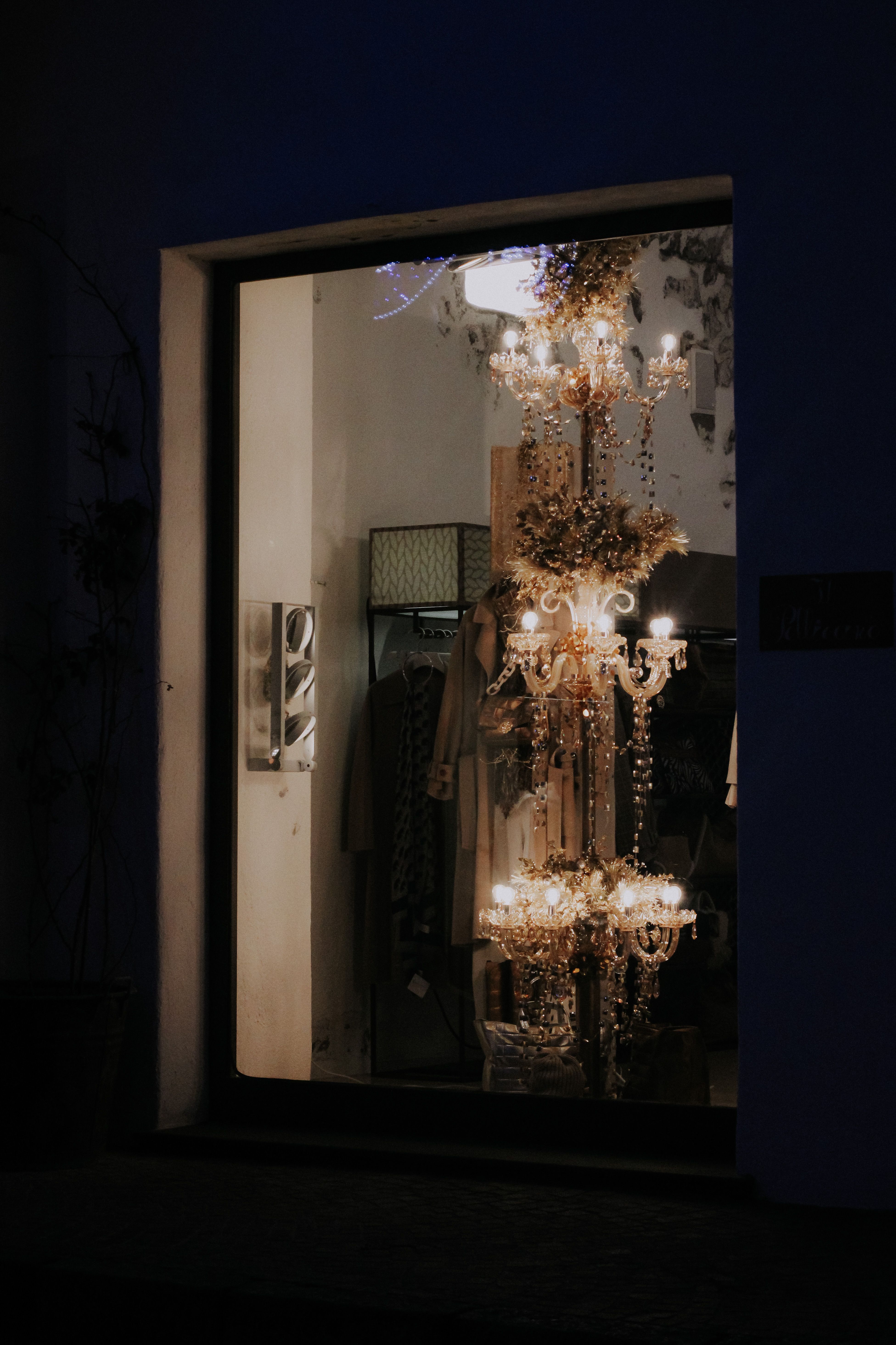 Elegant store window showcasing a beautifully illuminated chandelier inside.