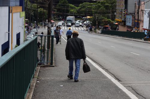 Free A person walking on a city sidewalk, capturing urban daily life. Stock Photo