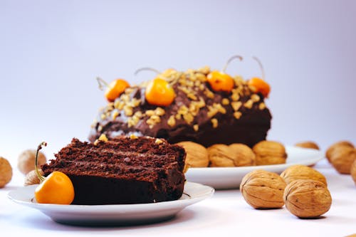 Close-up of a Slice of Chocolate Cake and Walnuts on a Table 