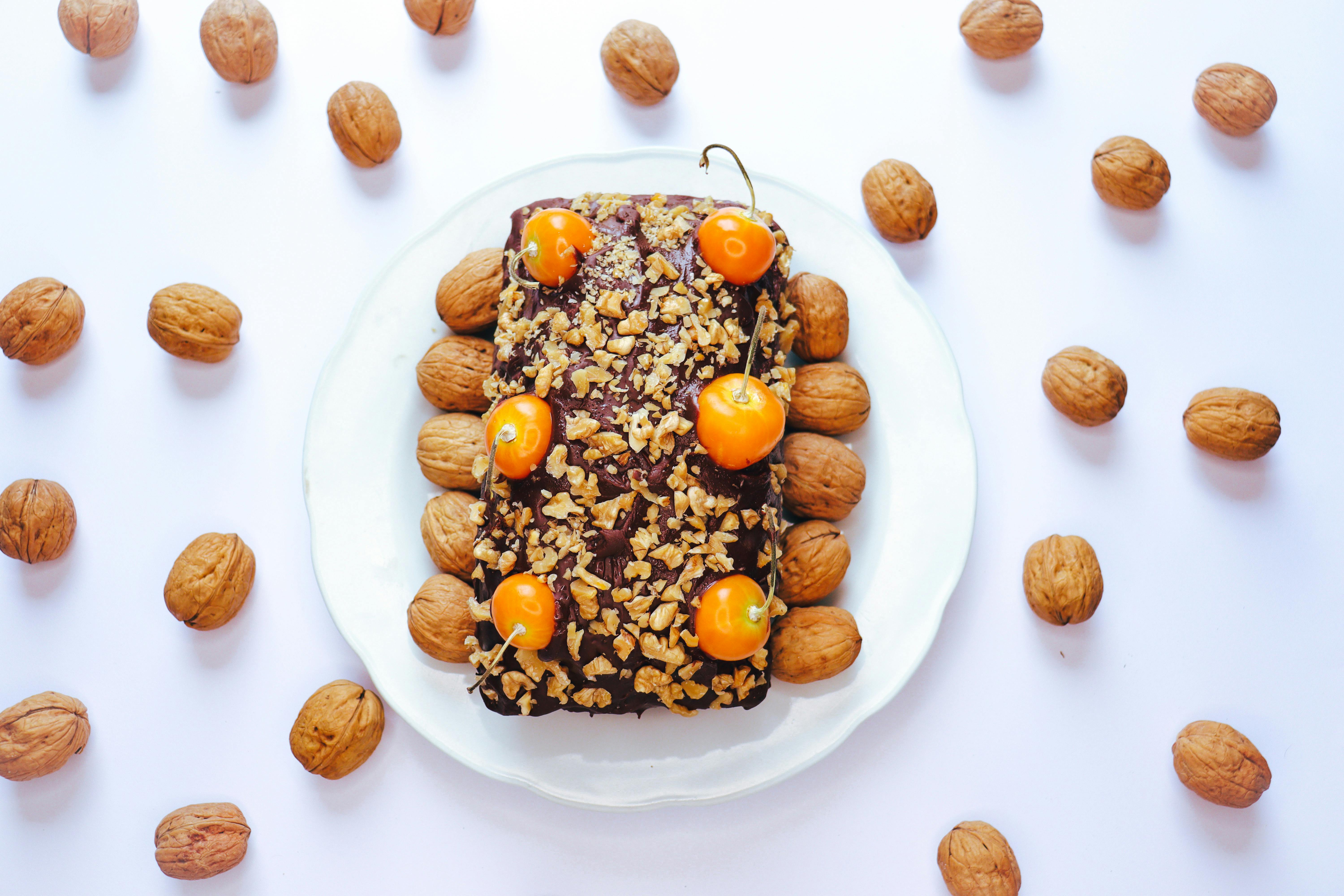 chocolate cake with fruit and nuts decor on table