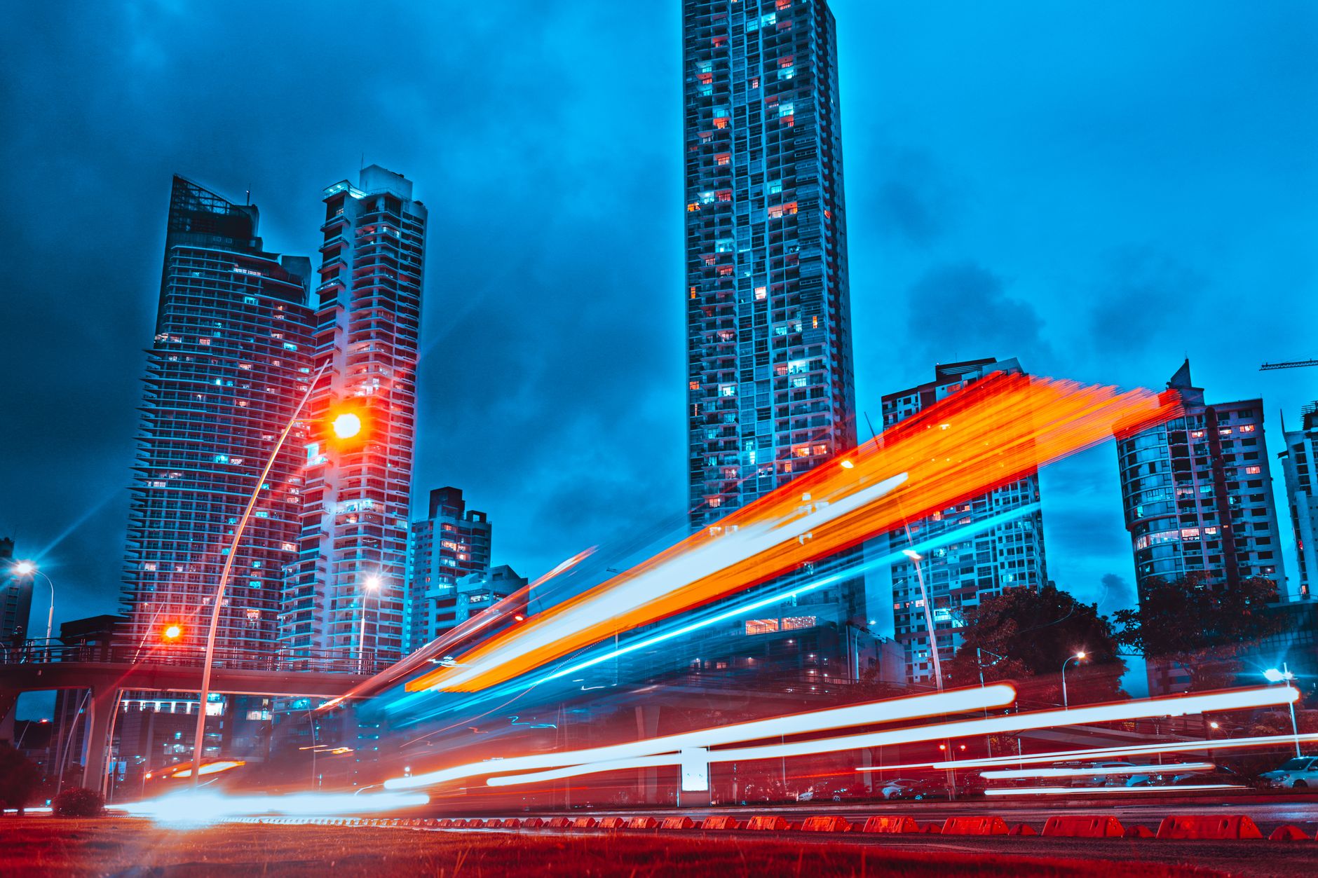 Stunning blue-toned cityscape of Panama City with dynamic light trails at night.