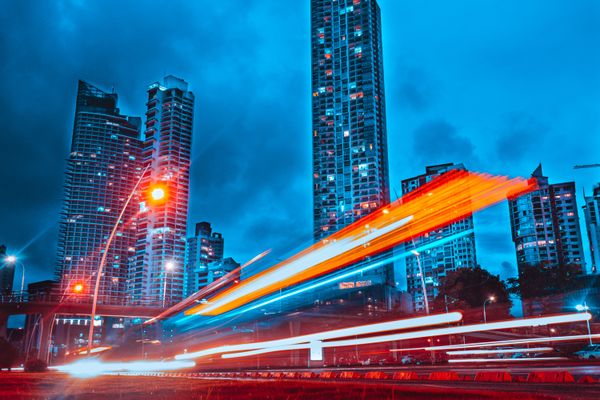 Deslumbrante paisagem urbana em tons de azul da Cidade do Panamá com trilhas de luz dinâmicas à noite.