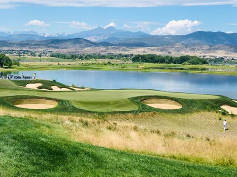 Championship golf course with mountain lake backdrop