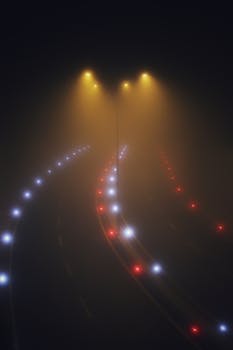 A foggy night view of an illuminated highway with colorful lights creating a mysterious ambiance.