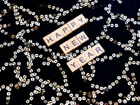 Scrabble tiles spell out 'Happy New Year' with festive decorations in Paris, France.