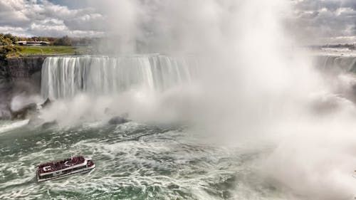 Boat Near Waterfalls during Daytime