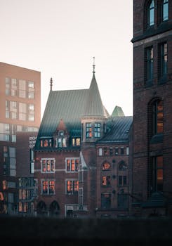 A moody view of Hamburg's historic and modern architecture at dusk, featuring red brick buildings.
