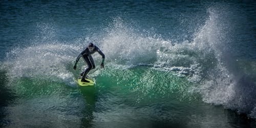 水域でサーフィンする男