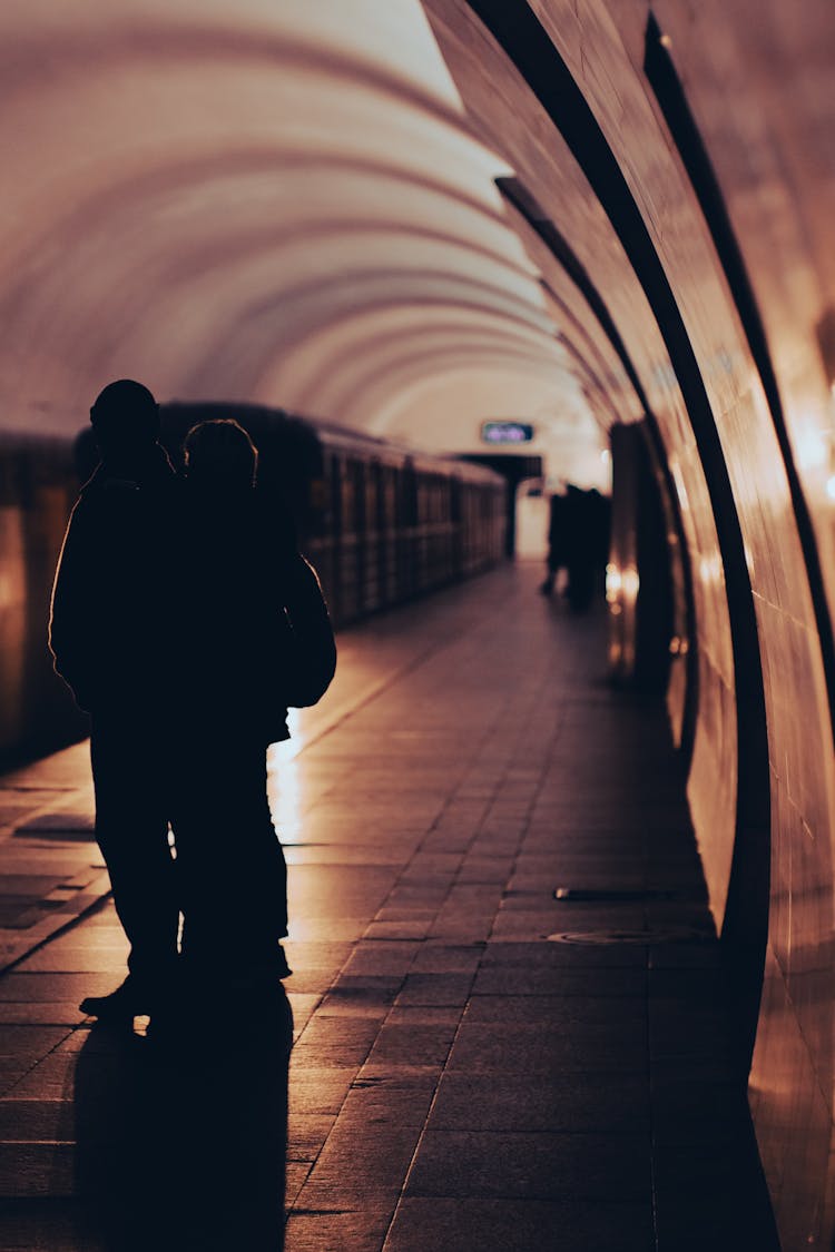 Silhouette Of A Couple Standing On A Subway Station