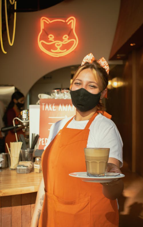 Barista in Face Mask and Apron with Coffee