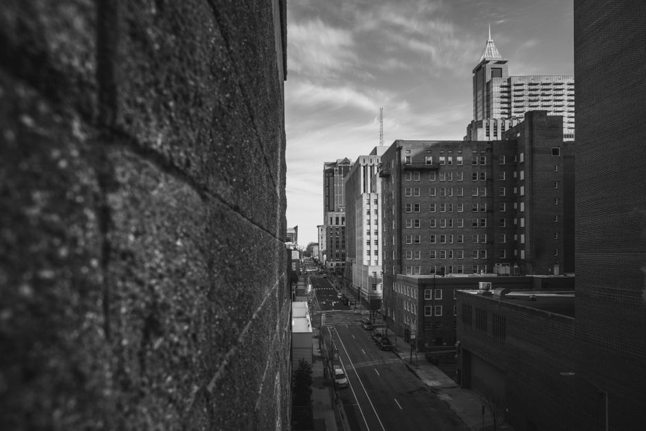 A captivating black and white street view of downtown Raleigh, NC, showcasing urban architecture and an empty road.