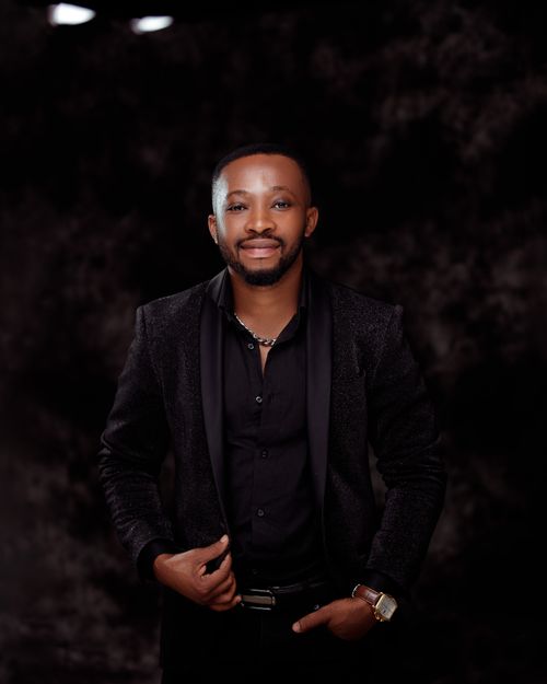 Free Portrait of a confident man in a formal black suit against a dark background. Stock Photo