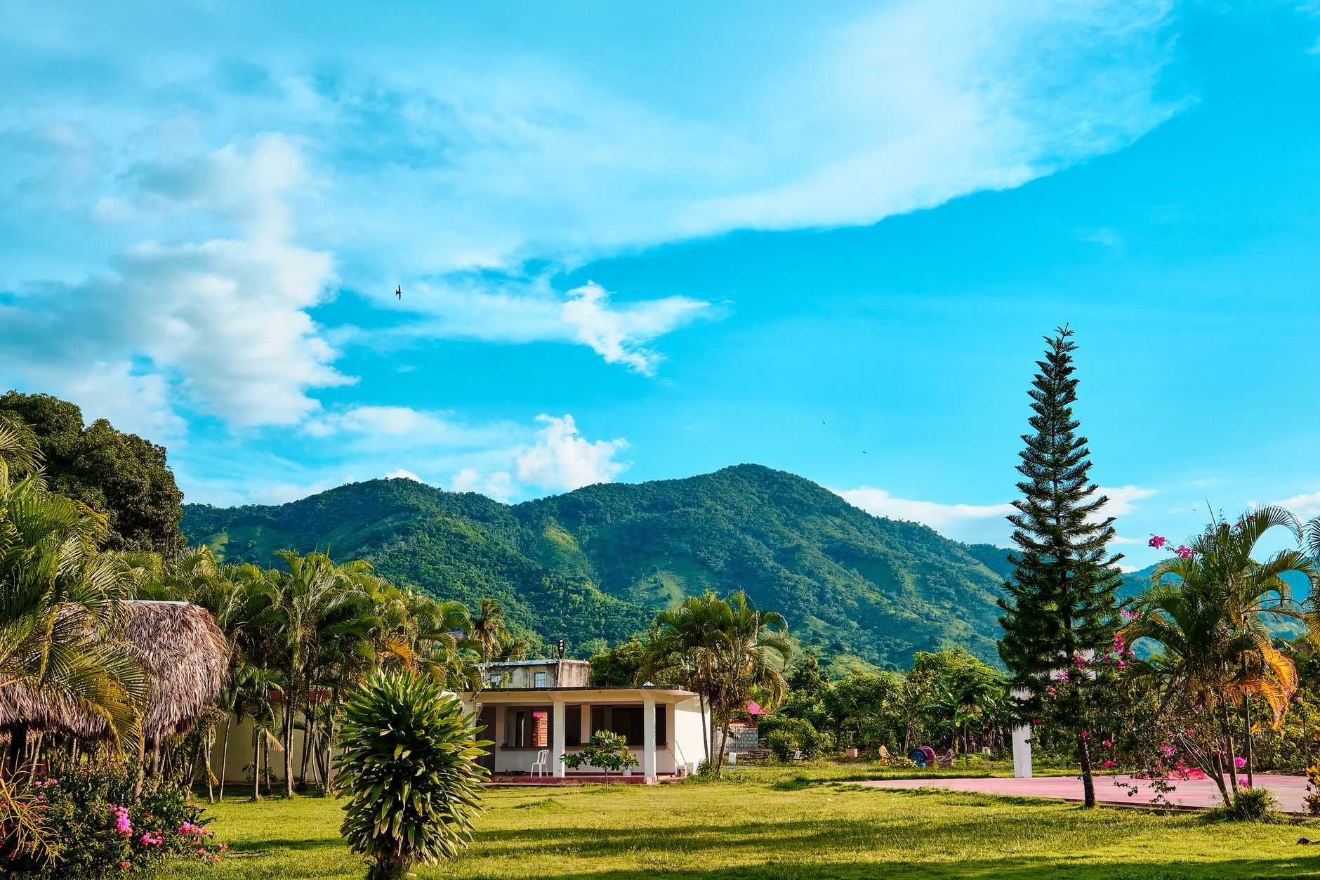Beautiful rural setting in Villa Altagracia with lush greenery and mountainous backdrop.