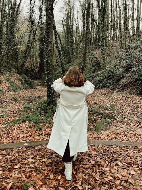 Back View of a Woman Walking in a Forest in Autumn