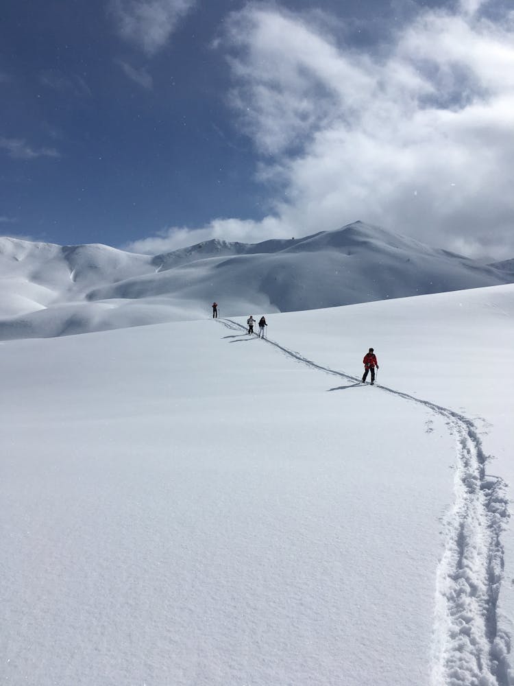 People In Mountains Covered In Snow 