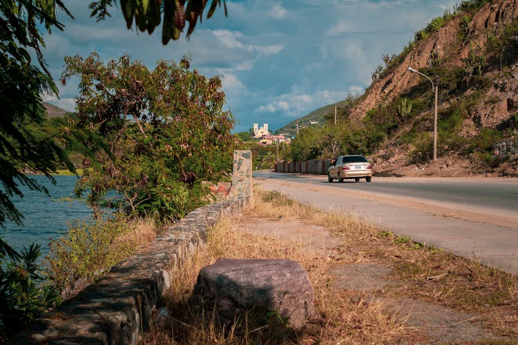 Car Driving On Road Near Sea In Mountains Landscape