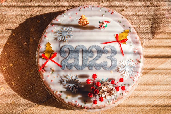 White cake with sparkly silver 2023 written on it