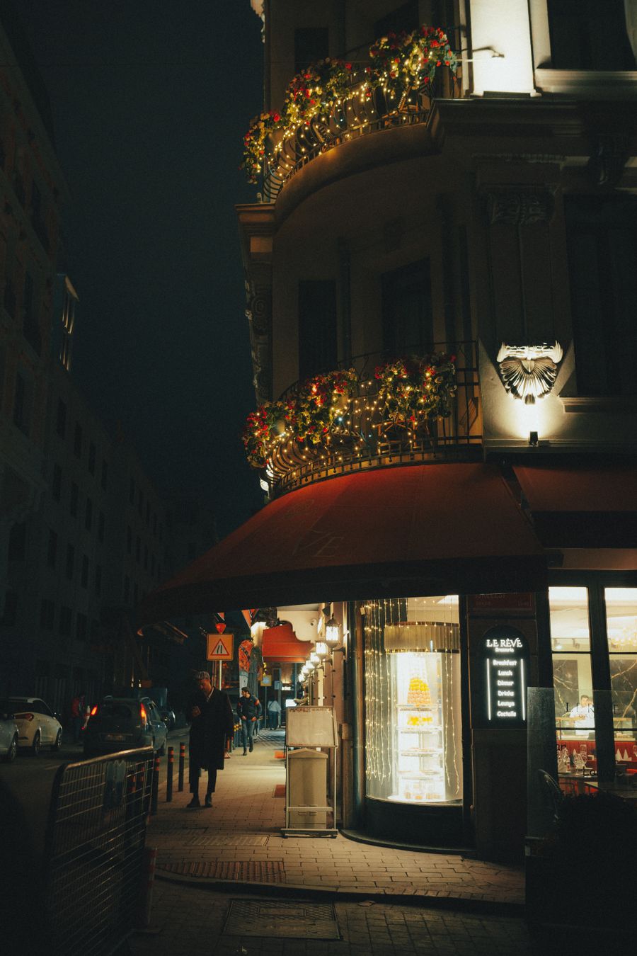 Gece bir sokak köşesi, ışıklarla süslü balkonlar