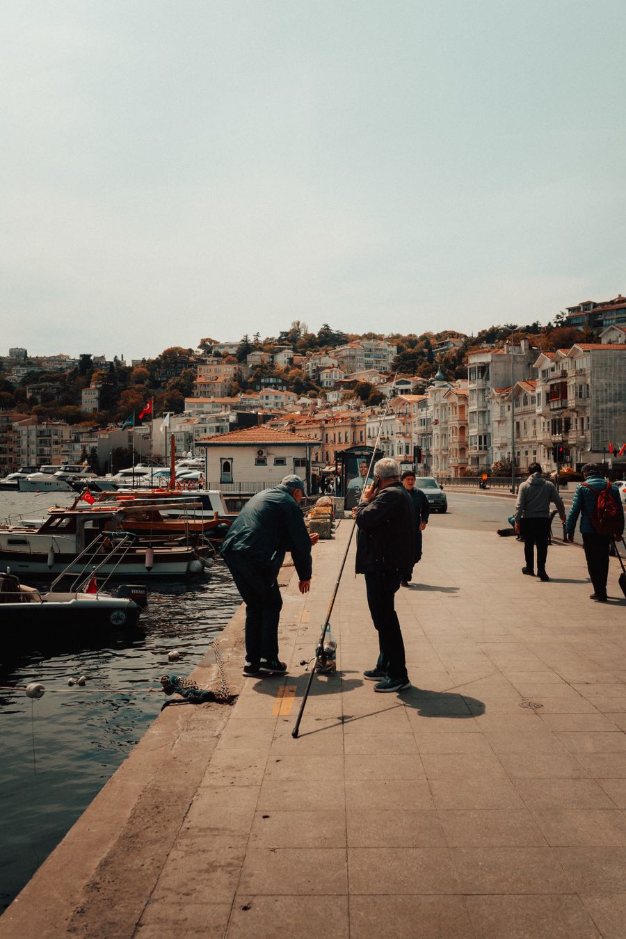 Limanın kenarında olta hazırlayan iki balıkçı