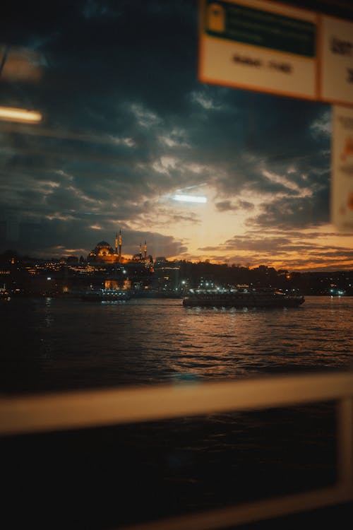 Illuminated Buildings and Mosques of Istanbul seen from the Bosphorus Strait at Sunset 