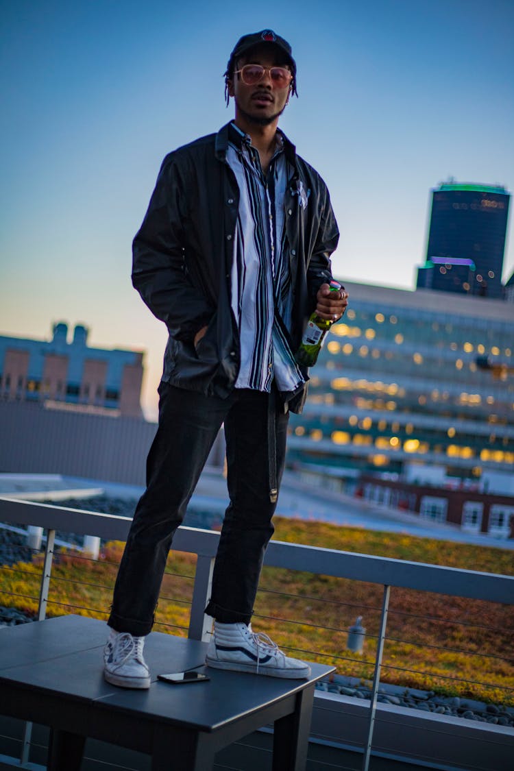 Man Holding Bottle Standing On Desk On Deck