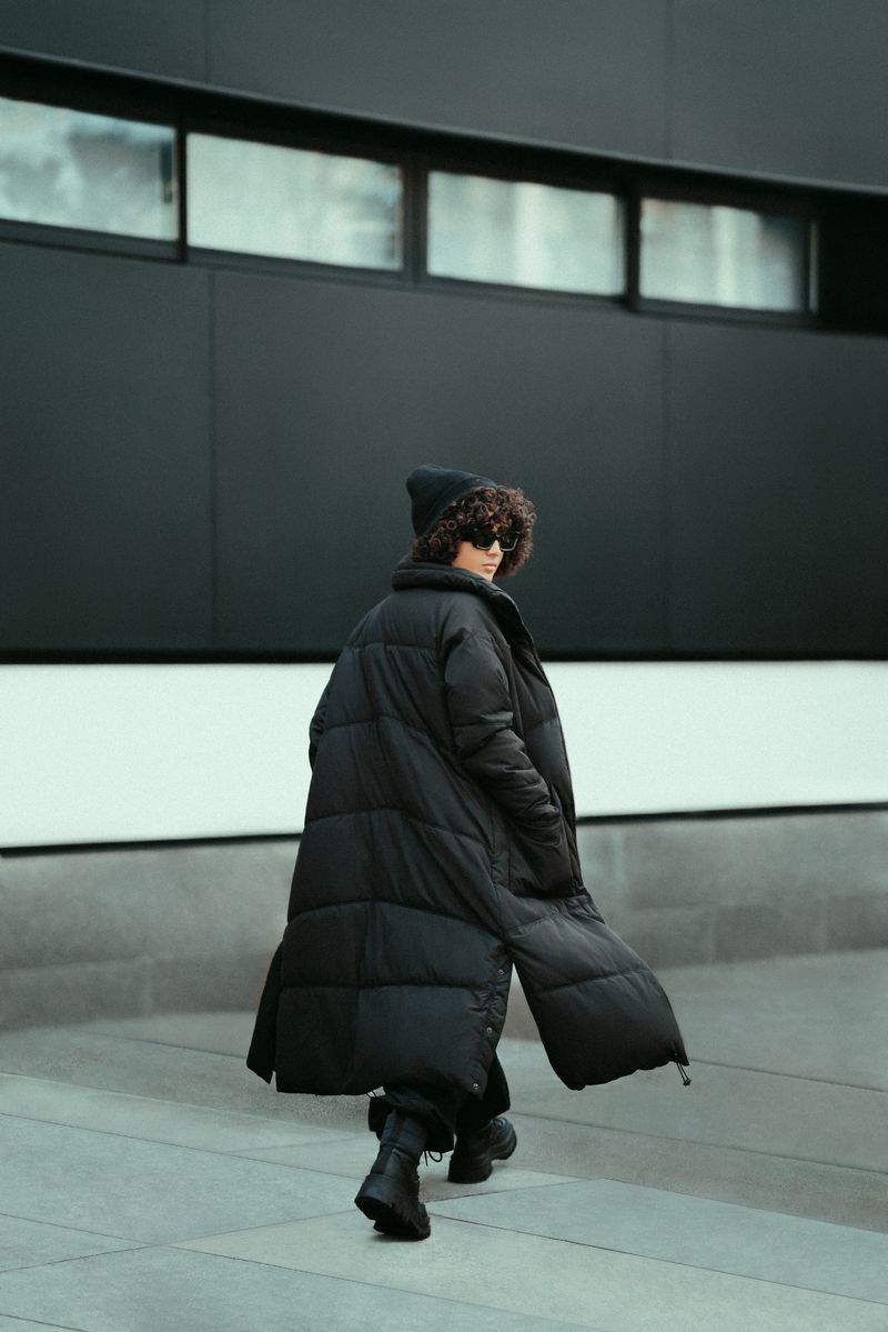 Woman in a long winter coat walking down a sidewalk