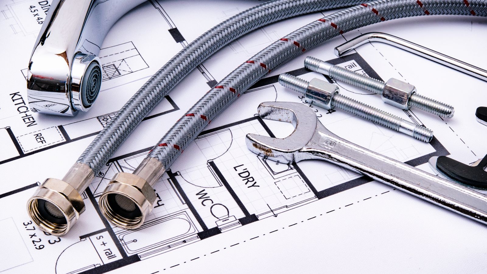 Plumbing fittings and tools laid out on house plans — what an installed price is made of