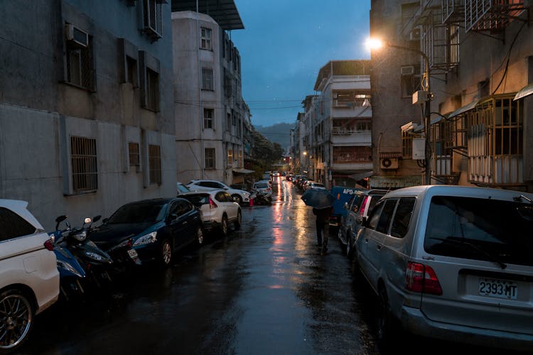 Cars Parked On The Wet Street During The Evening