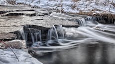 密西索加冬季的小溪宁静，有瀑布和白雪覆盖的岩石