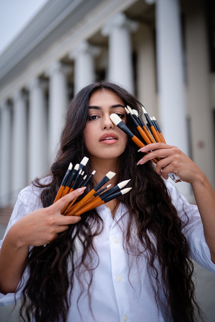 A Woman Holding Paintbrushes