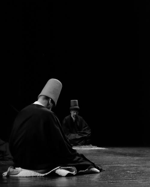 Men in Costumes Sitting on Stage during a Sufi Whirling Ceremony 