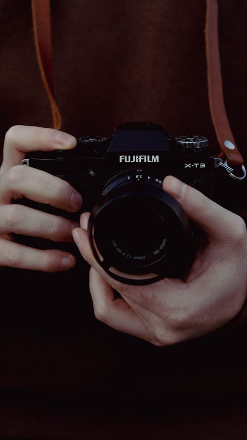 A Close-Up Shot of a Person Holding a Fujifilm Camera