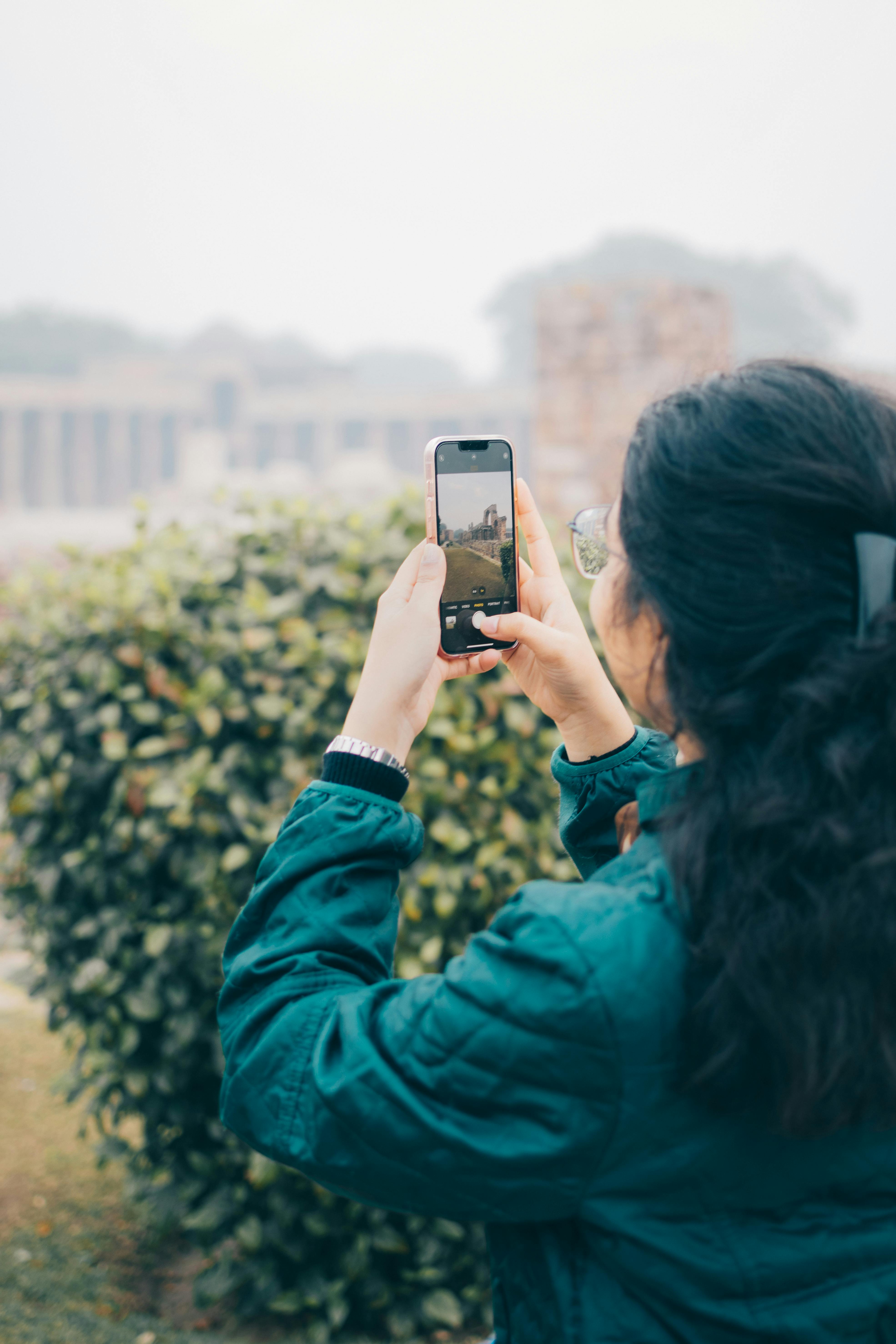 woman taking a picture of a garden