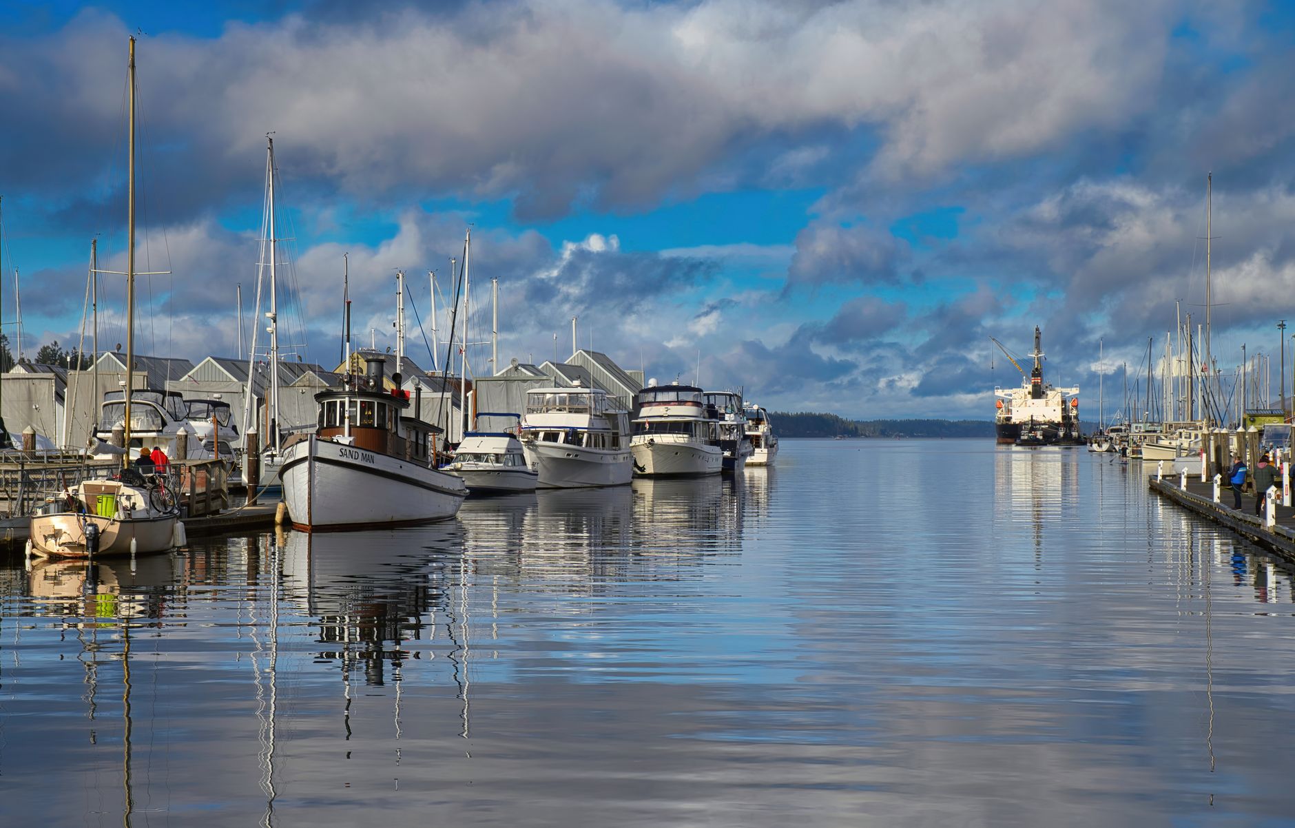 Beautiful capture of boats docked in Olympia Marina reflecting on calm waters under a blue sky.