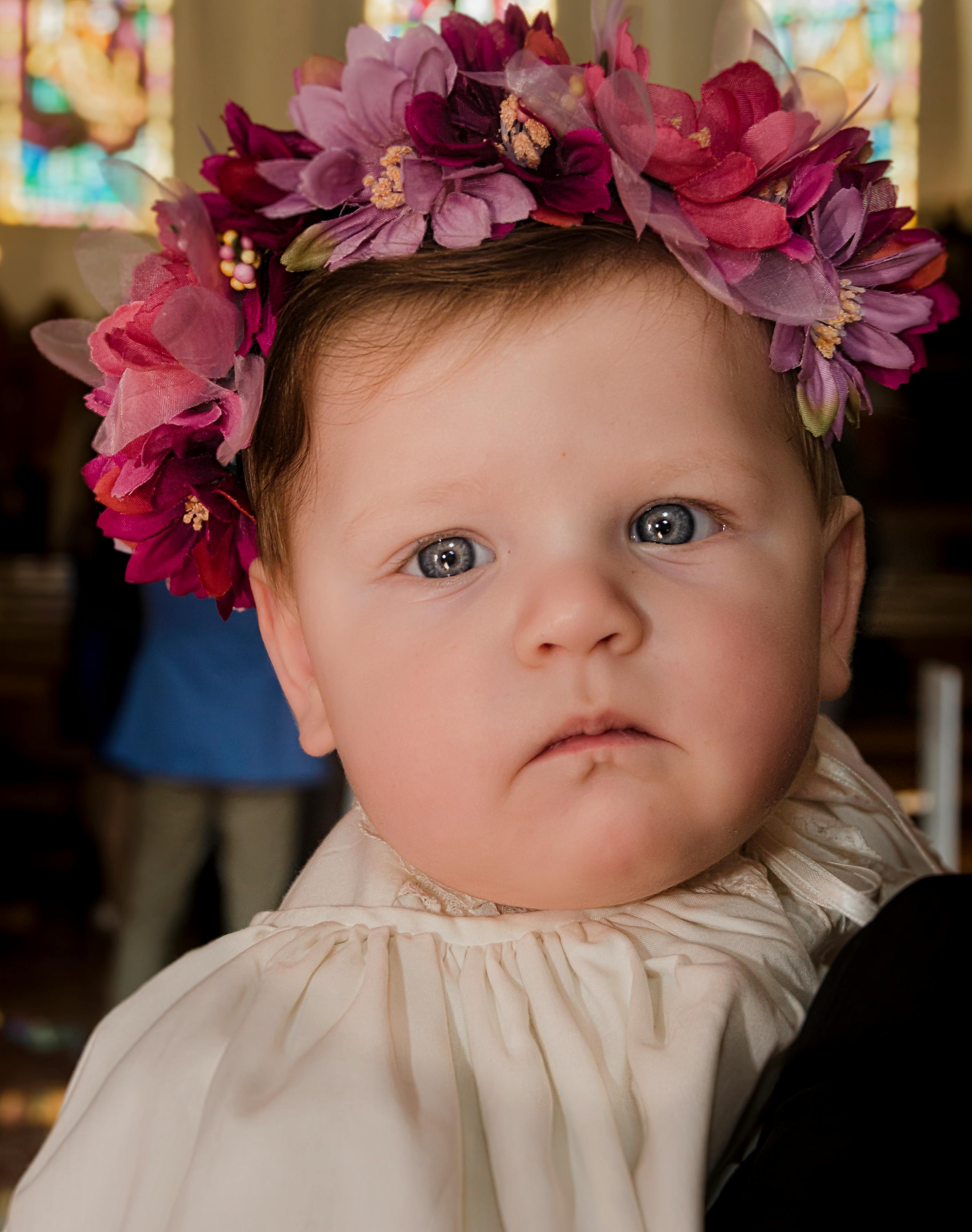 close up of a little girl wearing a pink flower crown