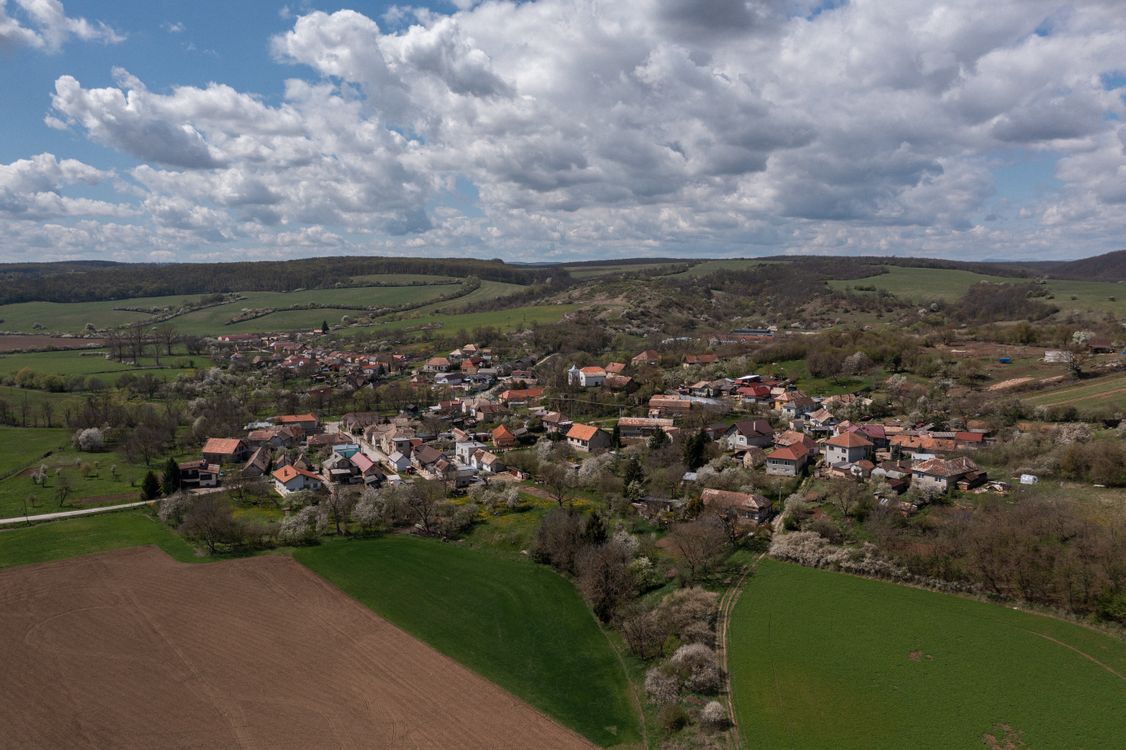 Free Stunning aerial view of Bretka village in Slovakia, surrounded by lush farmlands under a bright summer sky. Stock Photo