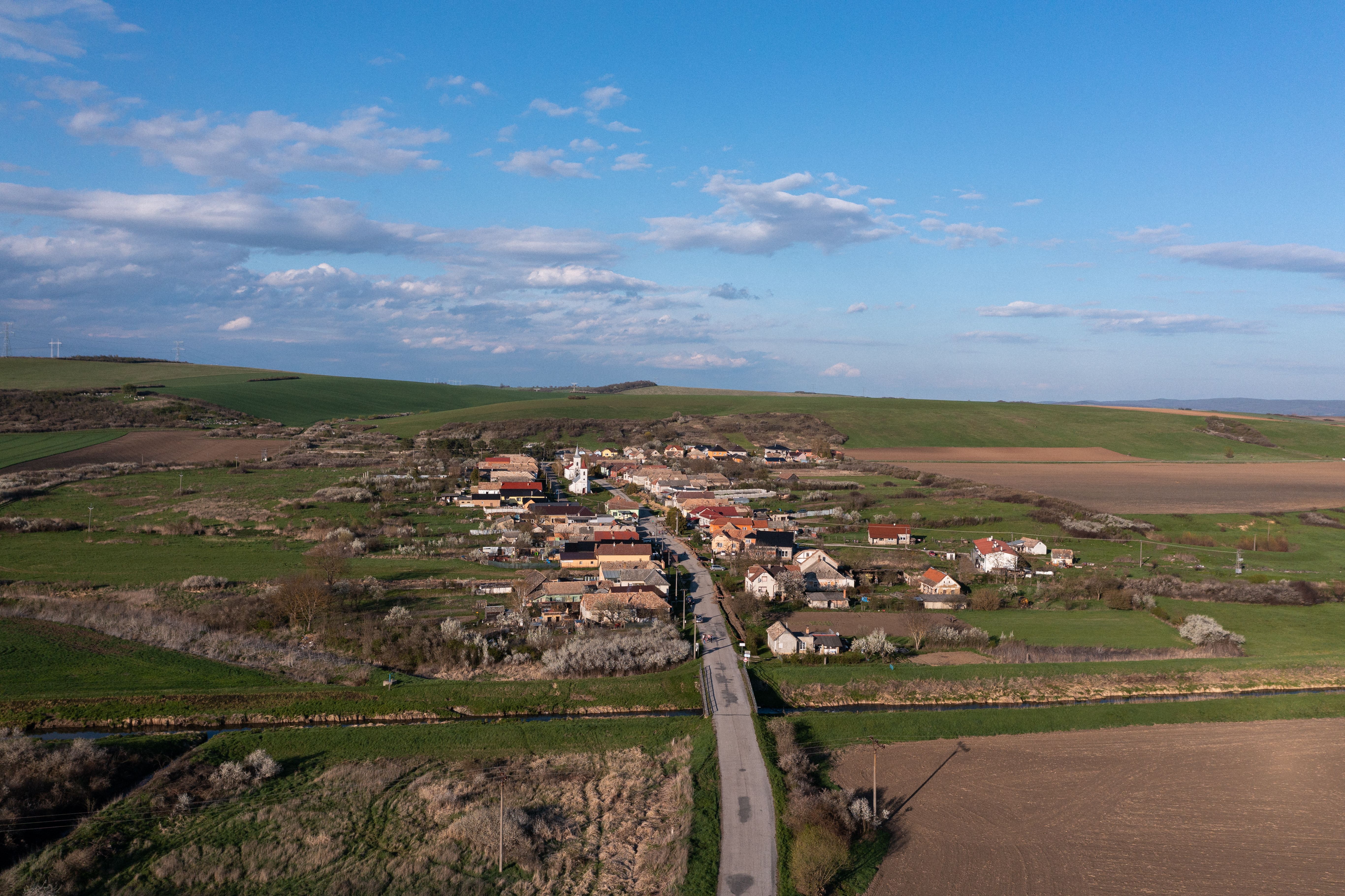 A stunning aerial view of Cakov village in Slovakia, showcasing rural fields and clear skies.