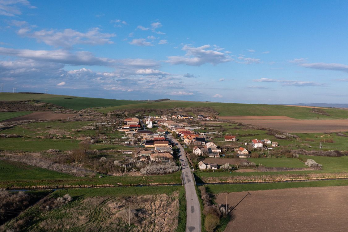 Free A stunning aerial view of Cakov village in Slovakia, showcasing rural fields and clear skies. Stock Photo