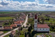 Scenic aerial view of Chanava village in Slovakia with church, fields, and rural landscape on a sunny day.