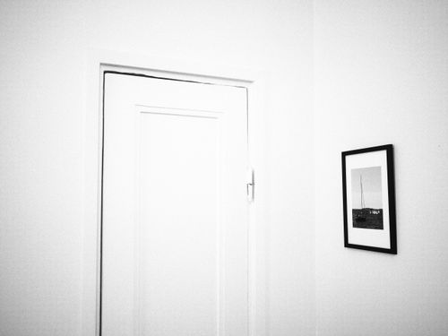 Free A black and white minimalist photo of a door and picture frame. Stock Photo