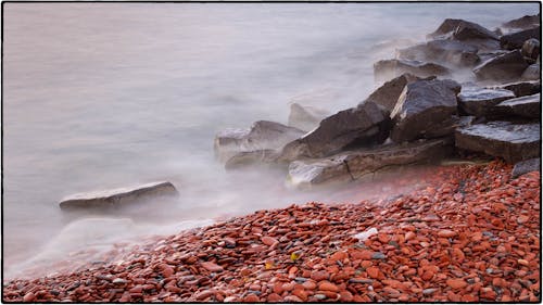 Brown Rock Formation on Body of Water at Daytime